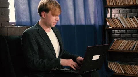 Focused young man working on a laptop in a cozy Stock Footage 316216020