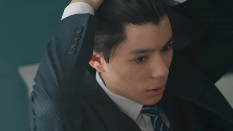 Focused young professional primes for interview. An earnest young man adjusts Stock Footage 342059252