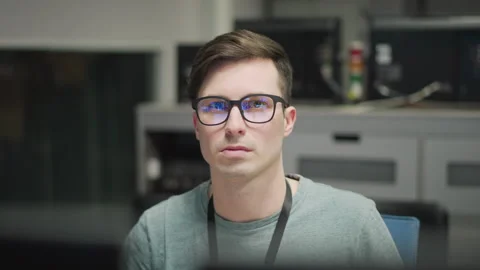 Focused young professional working with multiple monitors in modern office Stock Footage 317544334