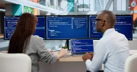 Focused Young Programmers Coding On Computers, Collaborating In Office Meetin 스톡 사진
