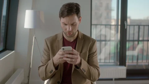 Focused young сaucasian man communicates with customers via smartphone Stock Footage 128451233