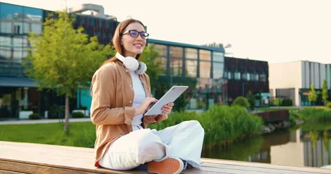 Focused young woman using a tablet device for online business or e-learning, scr Stock Footage 333706403