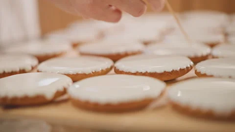 Focuses on intricate icing work on pumpkin shaped cookie. Studio shot capturing Stock Footage 346389831