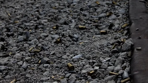 Focusing in on bullet shell casings on the ground (darkened) Stock Footage 113911482