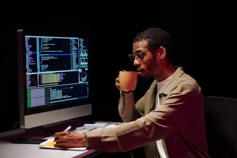Focusing on Coding with Coffee at Desk Stock-Fotos