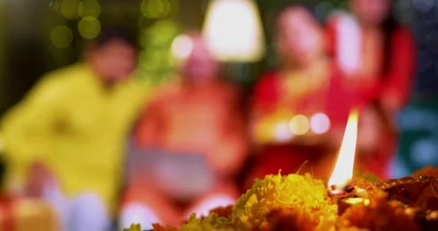 Focusing on Diwali diya flame while Indian family celebrates together Video stock 342350867