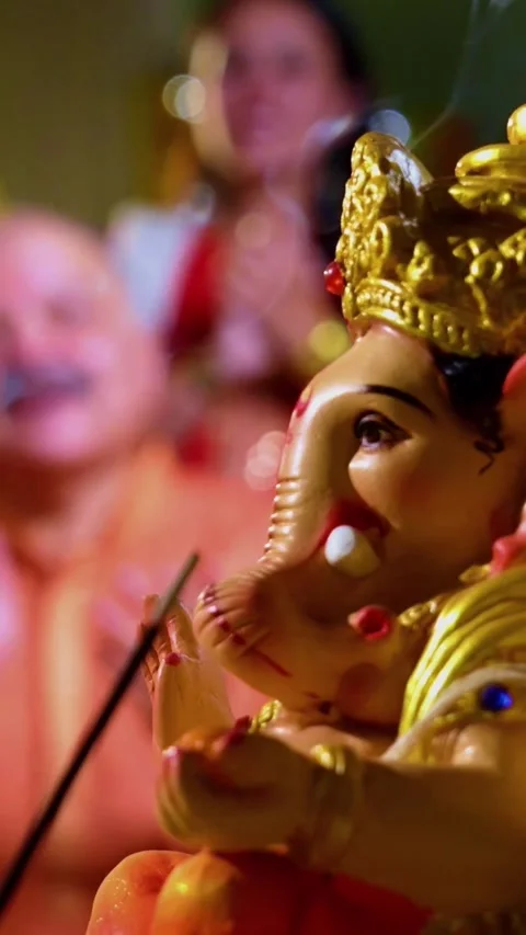 Focusing on Ganesh idol while Indian family prays with sweets thali Stock-Footage 342345985