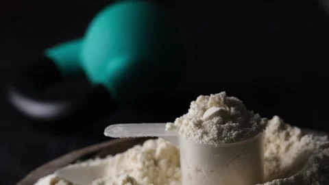 Whey Protein Powder in measuring scoop. Stock Photo