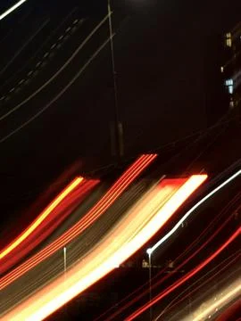 Focusing on neon light trails, long shadows under streetlights Stock Photos