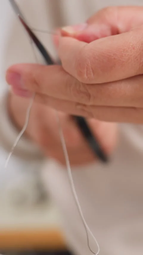 Focusing on skilled hands guiding delicate thread through fabrics, Capturing Stock Footage 326925458