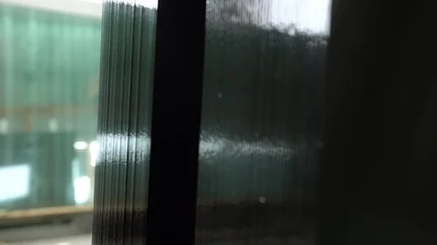 Focusing through a stack of black glass panels in the warehouse. Sheets of Stock Footage 124060681