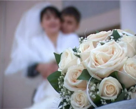 Focusing from wedding bouquet to kissing groom and bride Stock Footage