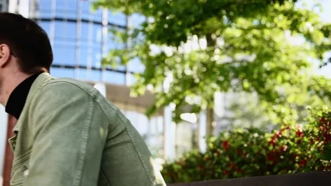 Focusing white man using digital smartphone sit on parapet outside, young Cau 스톡 동영상 207041547