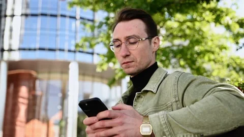Focusing white man using digital smartphone sit on parapet outside, young Cau Stock Footage 207041665