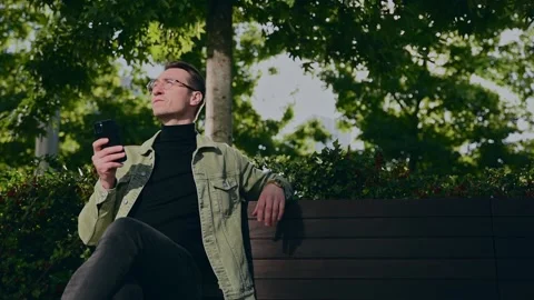 Focusing white man using digital smartphone sit on parapet outside, young Cau Stock Footage 207041810