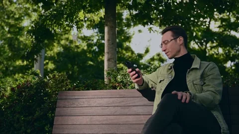 Focusing white man using digital smartphone sit on parapet outside, young Cau Stock Footage 207041877