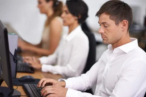 Focussed on the task. Shot of a handsome young office worker at his computer Stock Photos