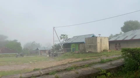 Fog after the rain at the central place in a small Indonesian village with homes Stock Footage 281326102