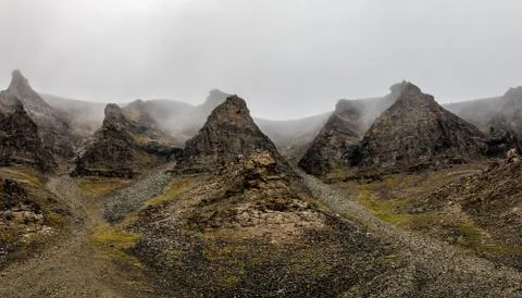 Fog and cliffs, mountain peak landscape. Spitsbergen, Svalbard, Norway Stock Photos