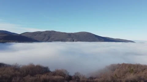 Fog and clouds covering the valley, drone footage. Flight above the clouds. Stock Footage 323563645