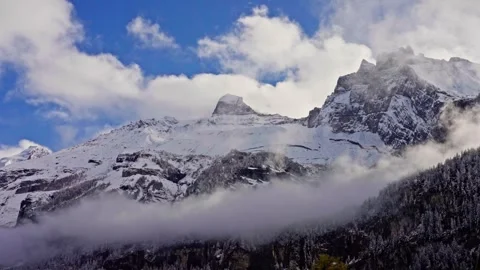 Fog and clouds curl on the wooded covered slopes of the Swiss Alps. Time lapse Stock-Footage 256074592