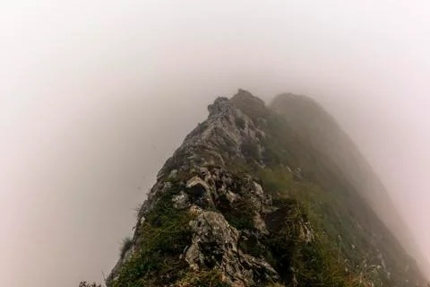 Fog and clouds enveloping the steep ridge of the majestic Schaefler peak in t Stock Photos