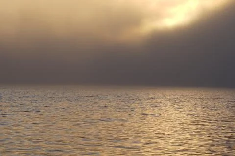 Fog and clouds hovering over the water. Stock Photos