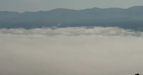 Fog and clouds in the valley, mountains in the background 動画素材 242930602