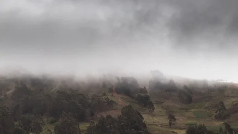 Fog and dark clouds quickly move past the Bolivian Andes mountains Stock Footage 120842520