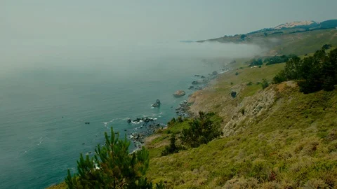 Fog and the Pacific Ocean collide with jagged coastline, Panoramic Highway Stock Footage 94092296