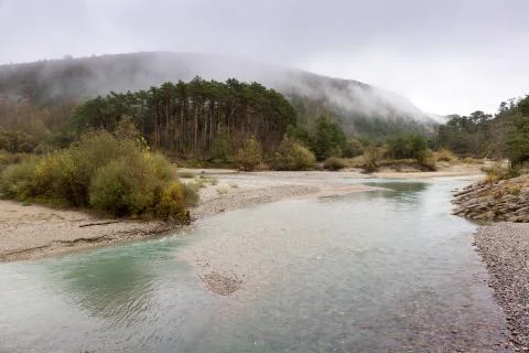 Fog climbs down mountains to the river near Nice, France Stock Photos