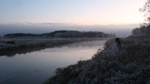 Fog crawling over winter lake and sun sets Stock Footage 225691320