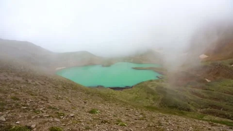 The fog dissipates over a high-mountainous lake with blue water. Stock Footage 158459537