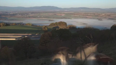 The fog that dissipates in the plain under the highway, in Switzerland. Stockbeeldmateriaal 83452479