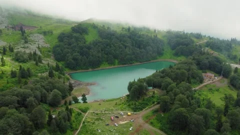 Fog entering mountain valley creating mystical scenery around lake Vídeo Stock 292805854