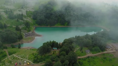 Fog entering mountain valley creating mystical scenery around lake Stock Footage 292805900