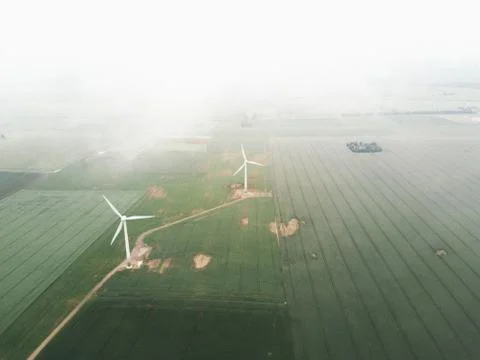 Fog on fields, wind turbines in the background. Stock Photos