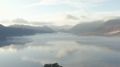 Fog filled lakes, during first light. Slow reveal of mirrored mountains Stock Footage 143243435