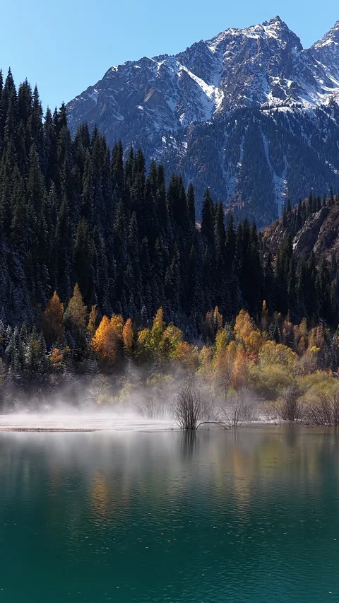 Fog floating over issyk lake with snow-capped mountains, Kazakhstan Vidéo 344963257