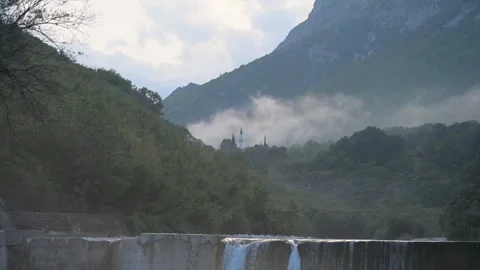 Fog in the foothills of mountains with a river waterfall and a mosque 库存影片 341806771