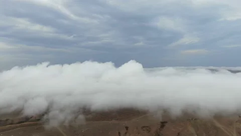 Fog goes through the hills under cloudy skies Stock Footage 132169441