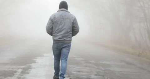 Fog landscape. Man walking alone on scary foggy misty road. Stock Footage 166270440