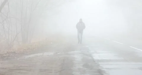 Fog landscape. Man walking alone on scary foggy misty road. Stock Footage 166270593