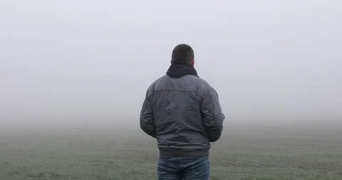Fog landscape. Man walking alone on scary foggy misty road. Stock Footage 166270665