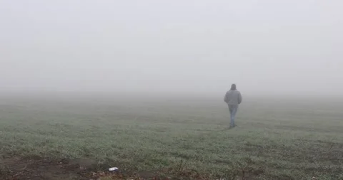 Fog landscape. Man walking alone on scary foggy misty road. Stock Footage 166273871