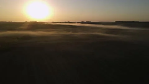 Fog lay low over the field at sunset, shooting from a drone Stock Footage 211366543