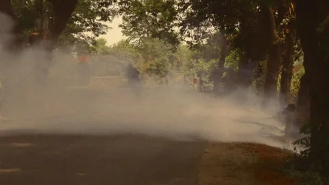 Fog machine generating white smoke on a road 스톡 동영상 332762079