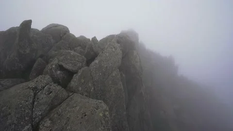 Fog, mist and mountain cloud rolling in over boulders and rocks Stock Footage 143393353