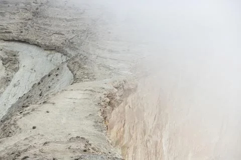 Fog in mountains. Sandy colored rocks blurred in fog. Empty sheer cliffs. Copy Stock-Fotos
