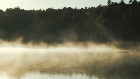 Fog or mist rising over lake surface in autumn. Sunlight water surface in fall Stock Footage 141284689
